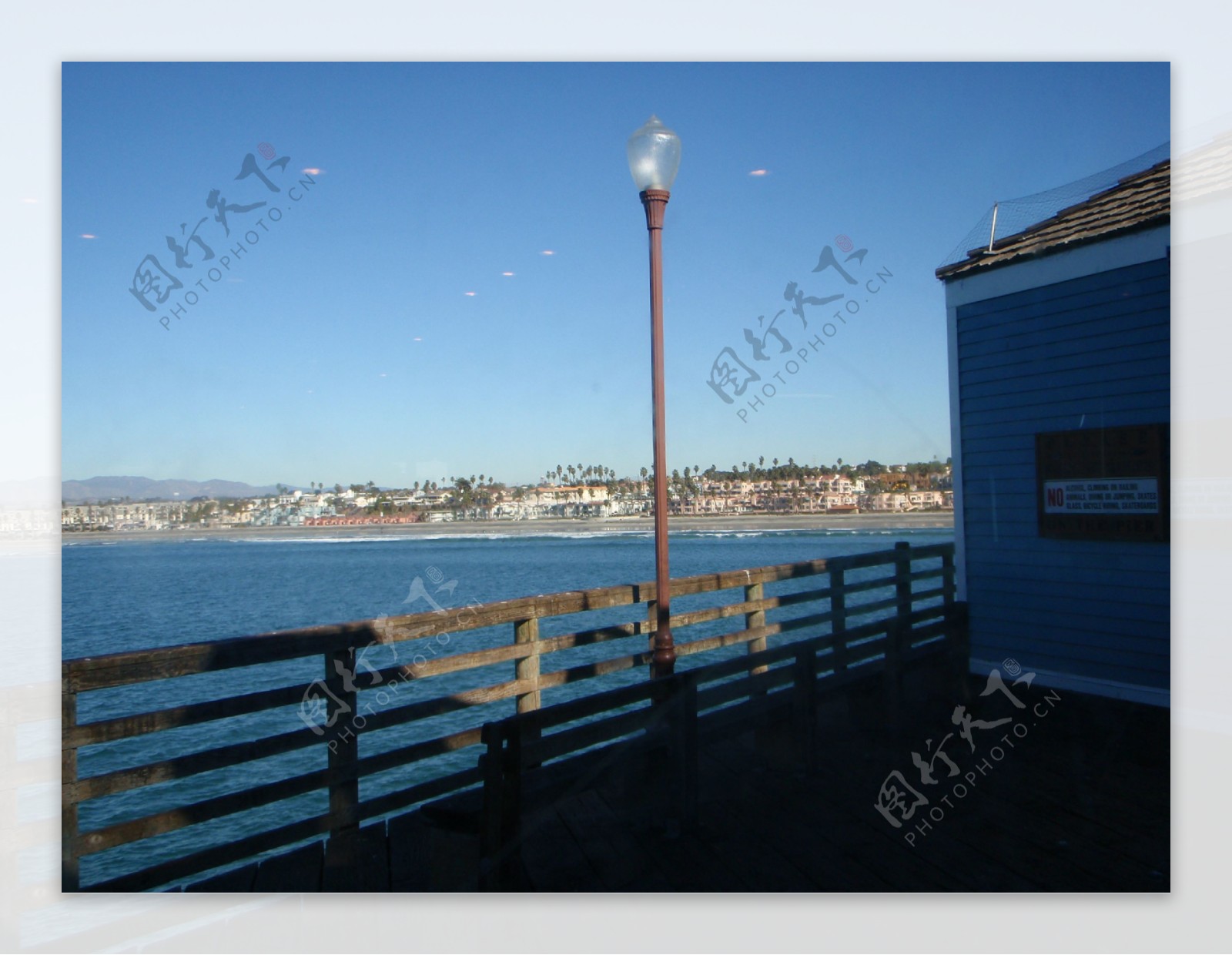 大海栅栏海边的房子波浪蓝天图片