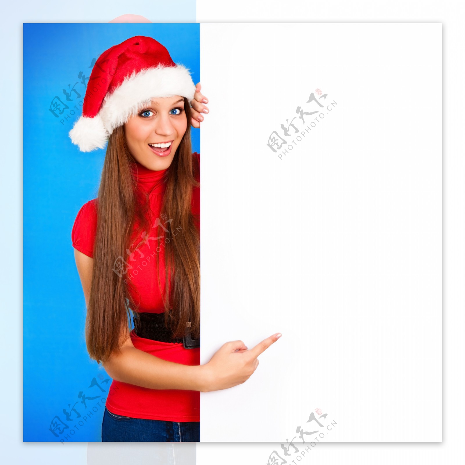 圣诞指着空白广告牌的漂亮微笑美女图片