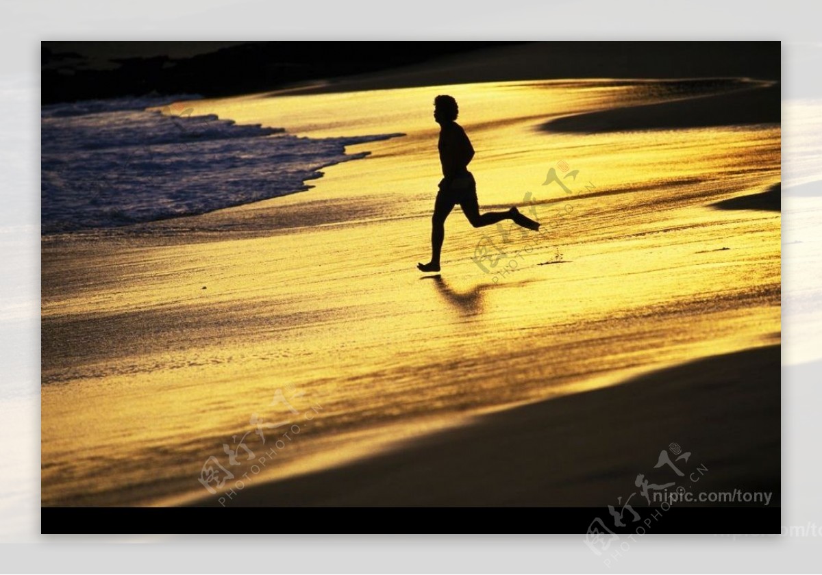 傍晚在沙滩跑步的男子图片