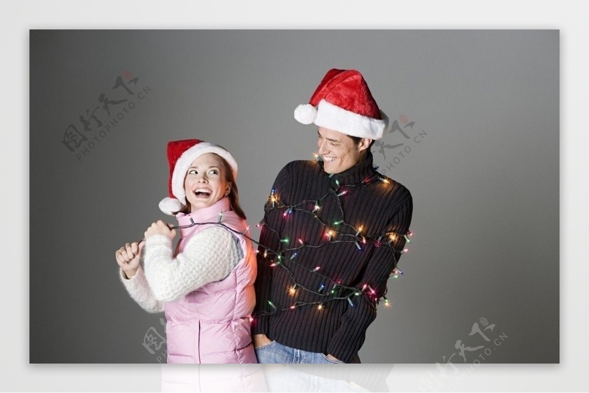 圣诞美女拉着满身彩灯的男友图片