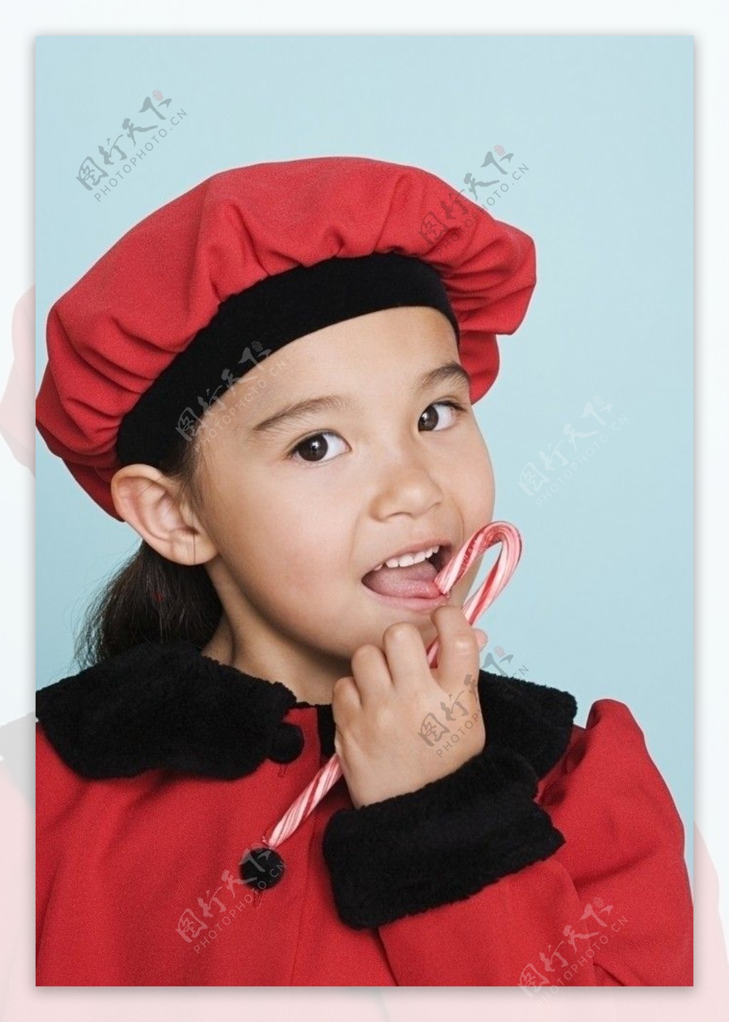 吃圣诞拐杖糖的甜蜜小女孩图片