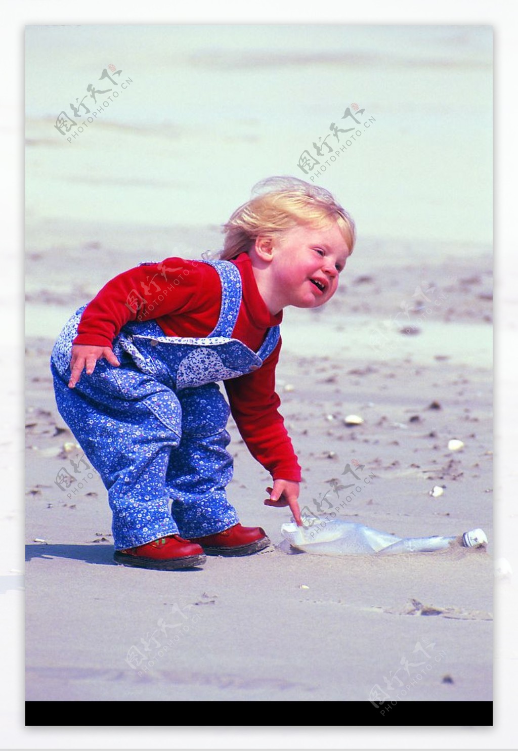 沙滩上捡塑料瓶的小女孩图片