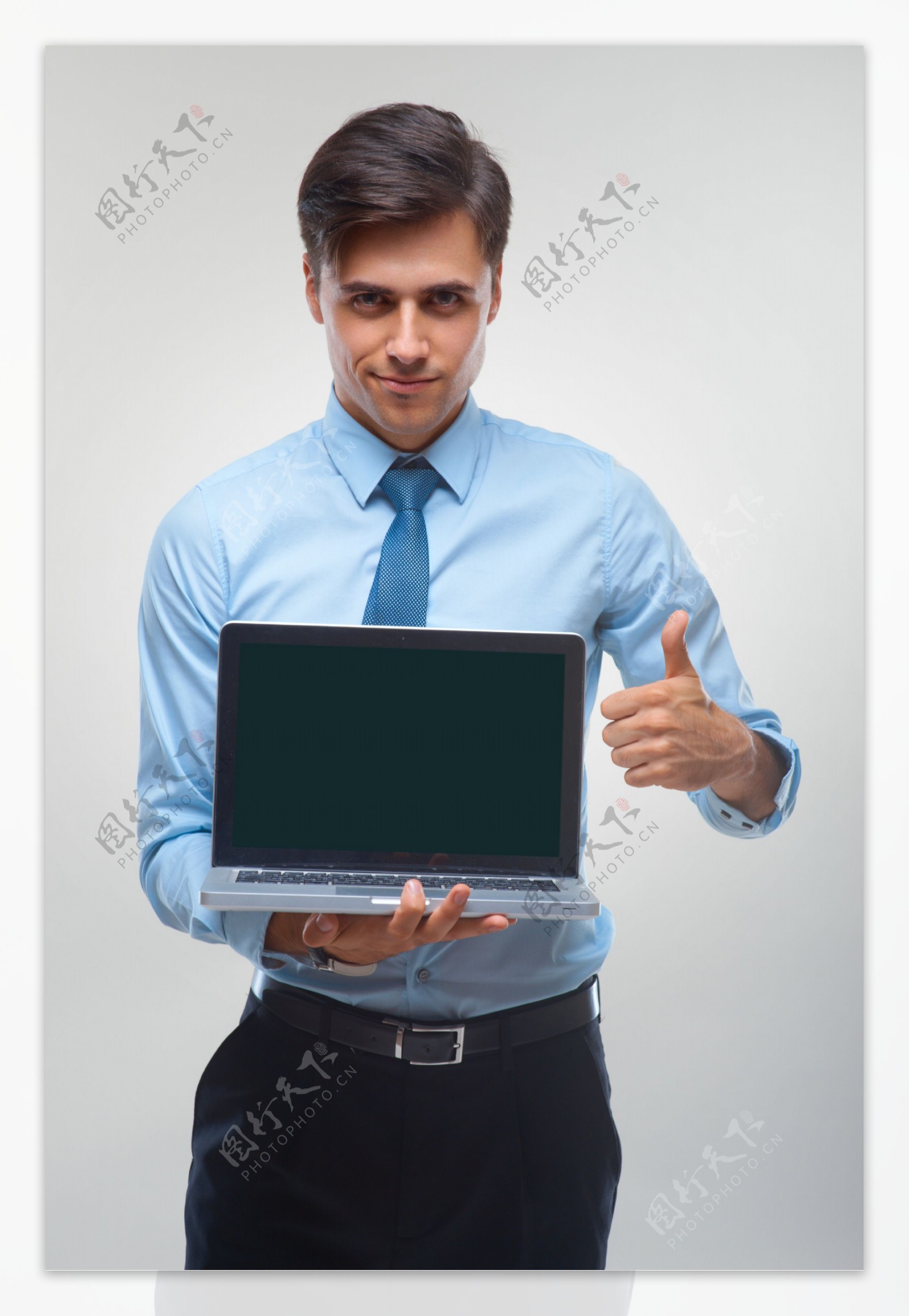 拿着电脑竖起大拇指的男人图片