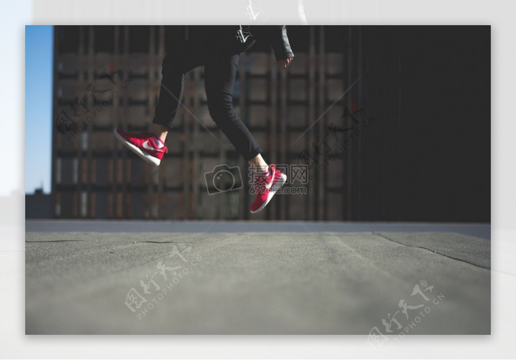 人类在黑色运动长裤随着红色耐克运动鞋跳