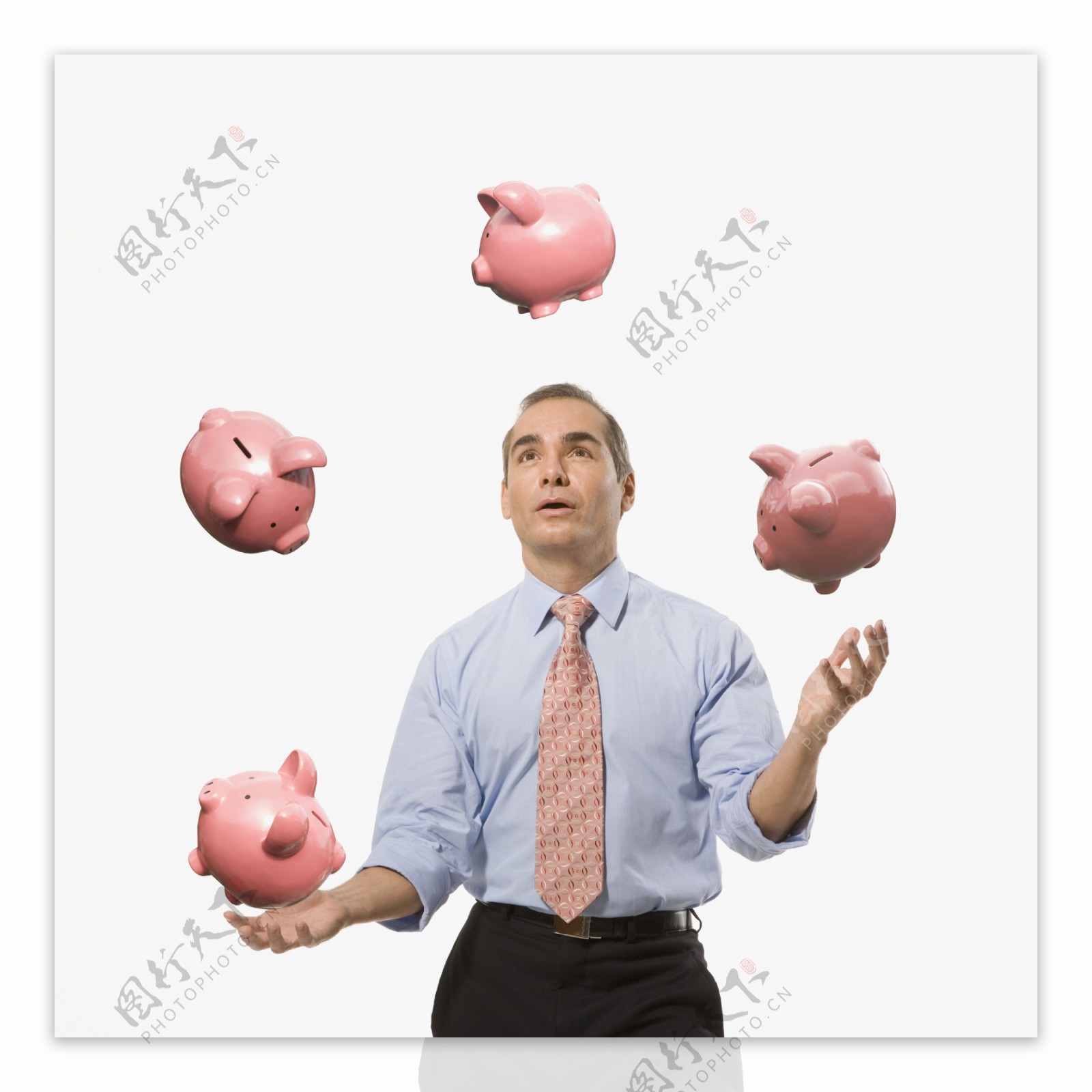 男人拿小猪存钱罐玩杂技图片