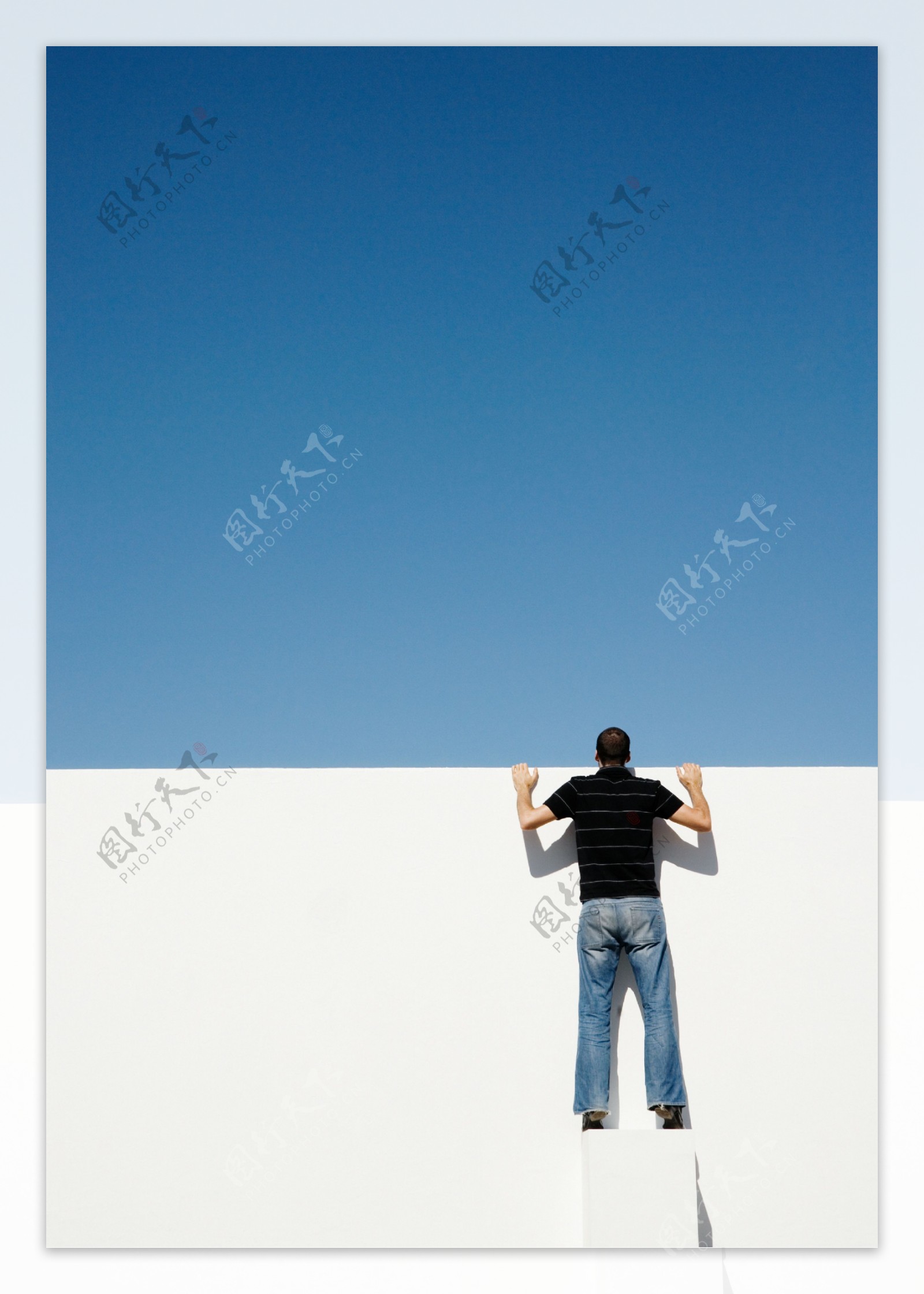 站在立方体上向上望的男人背影图片