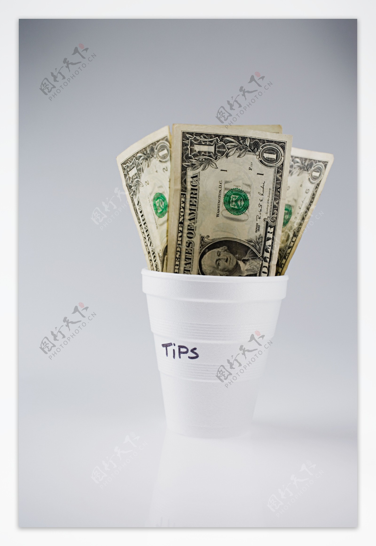 杯子里的美元钞票特写图片