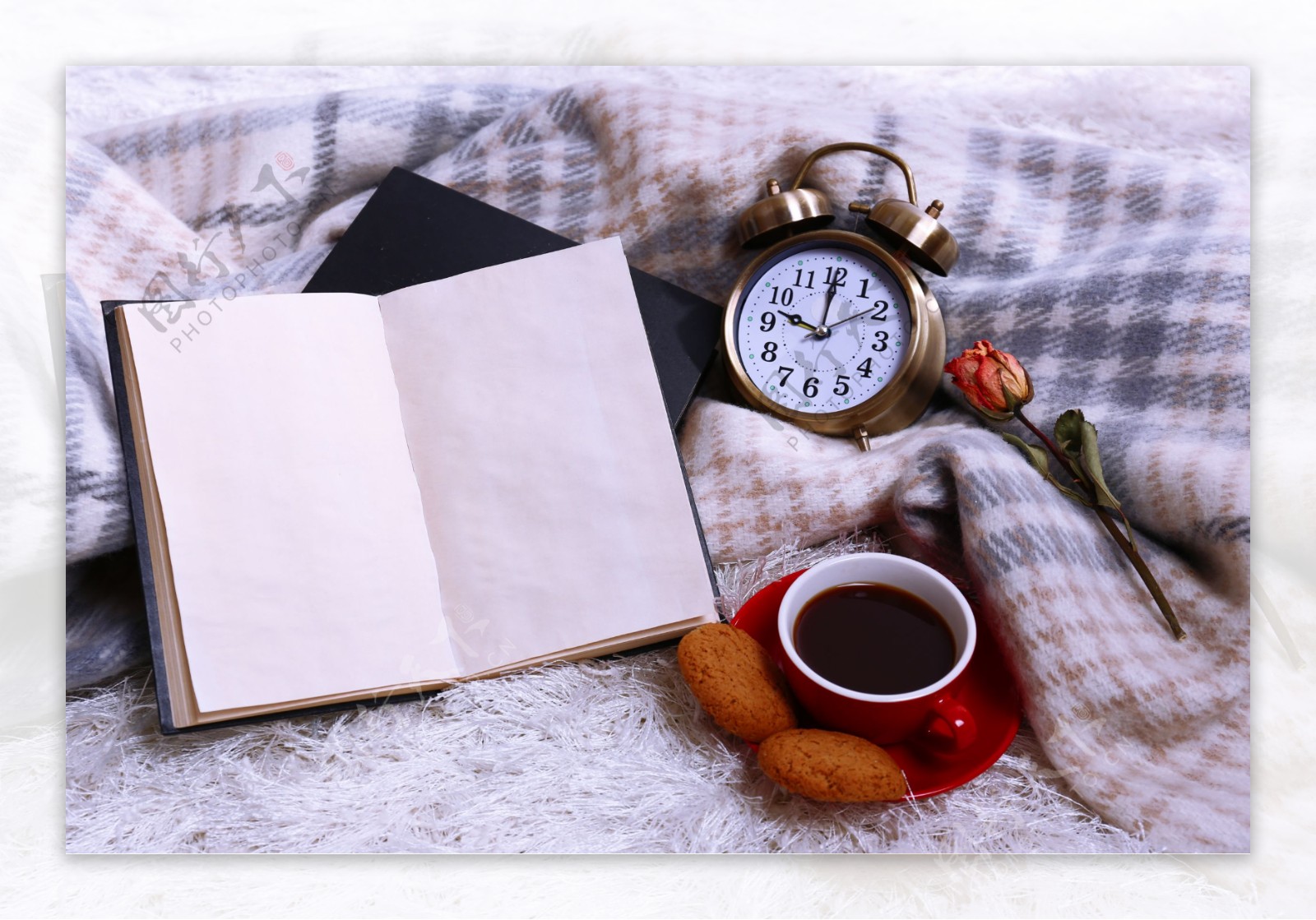 床单边的闹钟书本和红茶图片