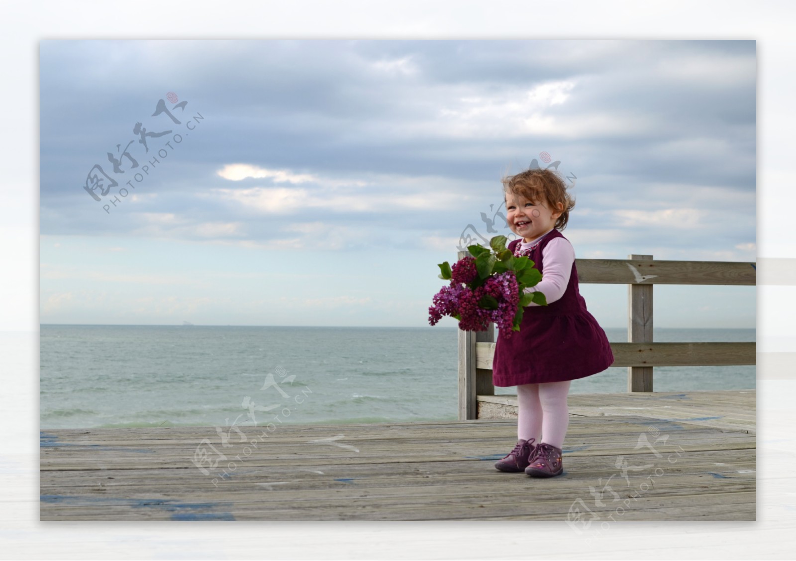 站在海边拿着鲜花的外国小女孩图片