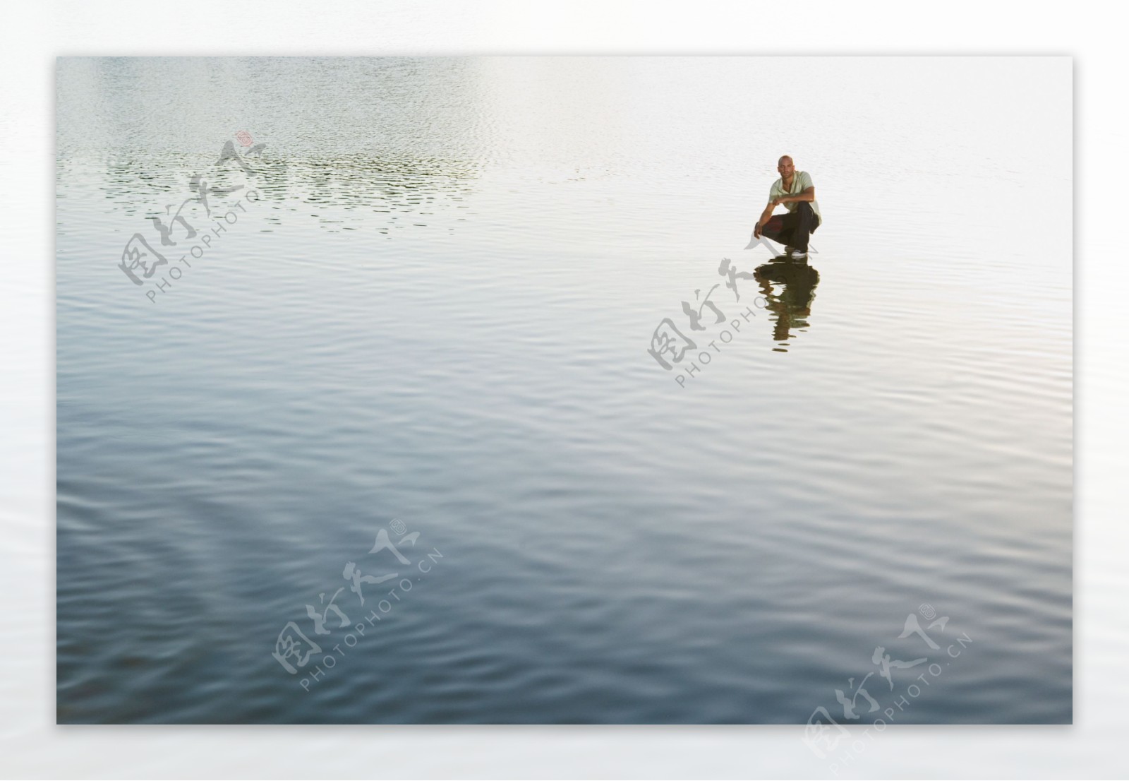 远处蹲在水面上的男人图片