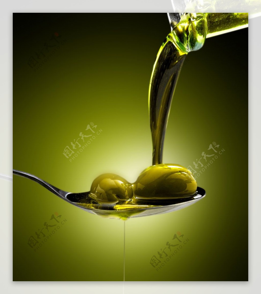 倒在勺子上的橄榄油和橄榄图片