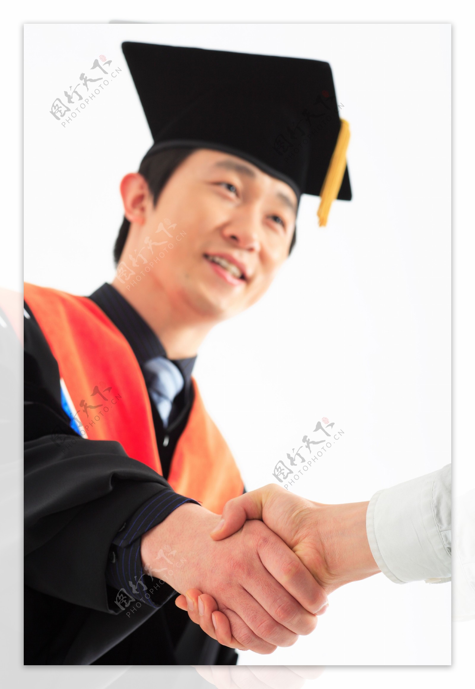 戴着博士帽面带微笑握手的男人图片图片