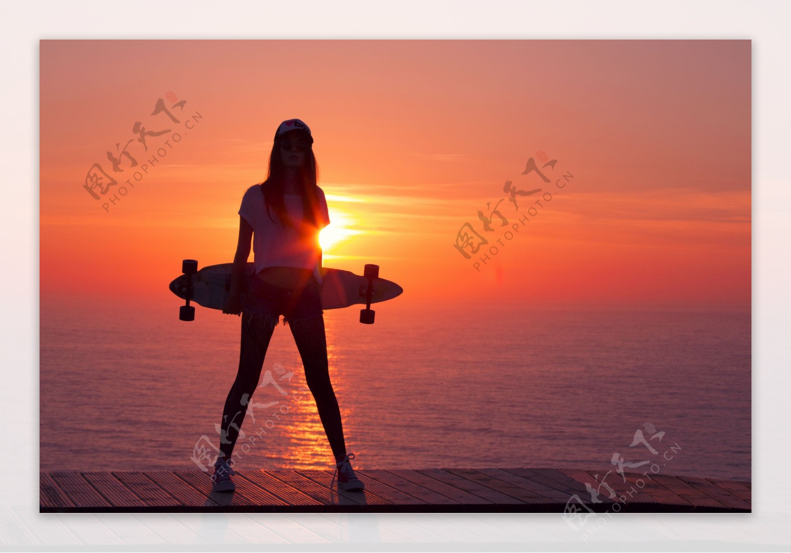海边抱着滑板车的美女图片