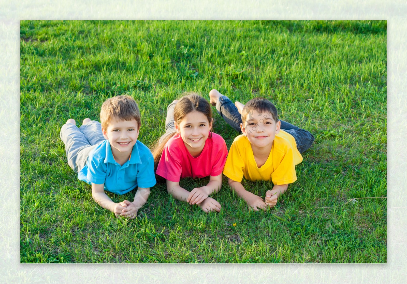 趴在草地上的三个小孩图片