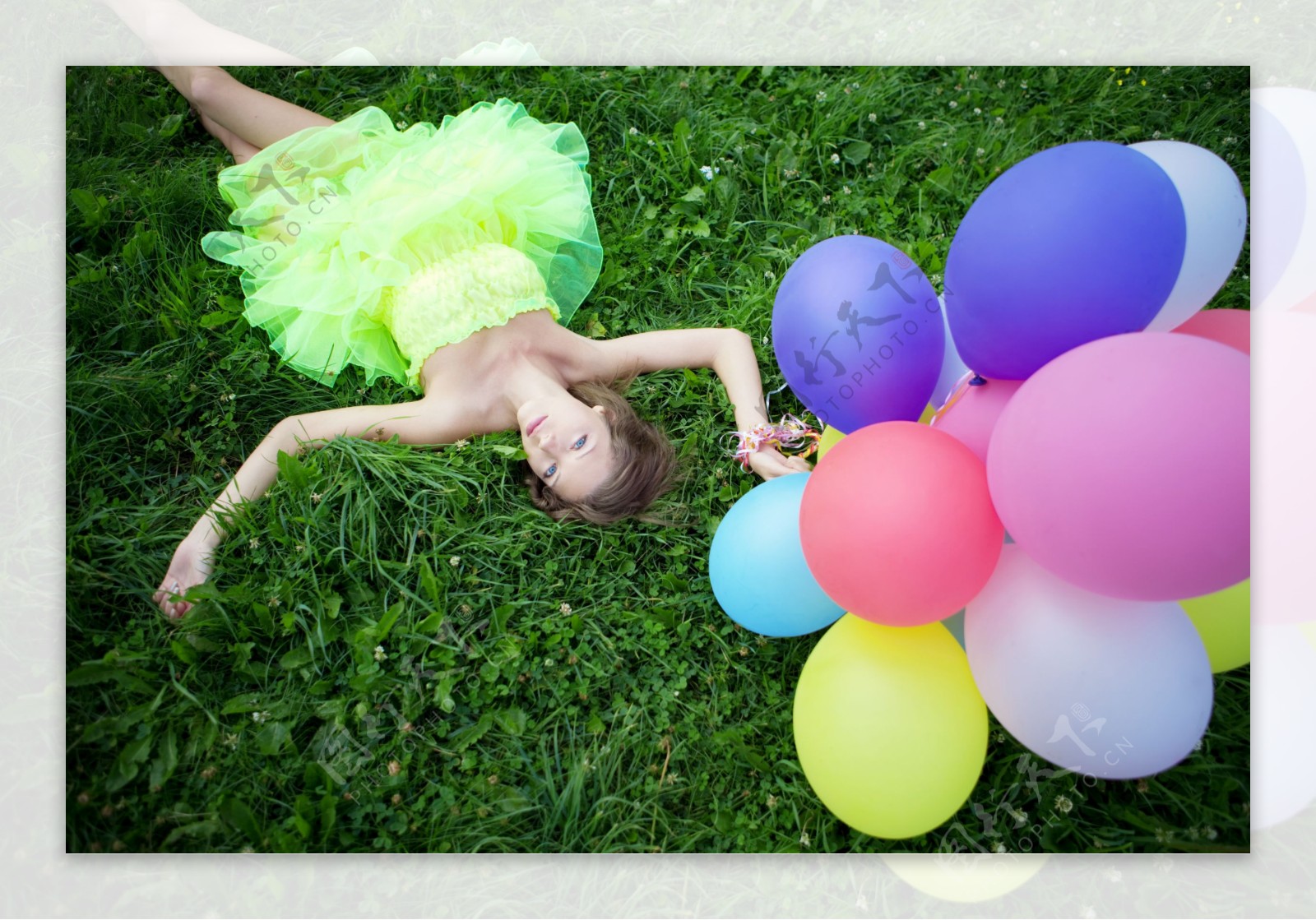 拿着气球躺在草地上的女孩图片