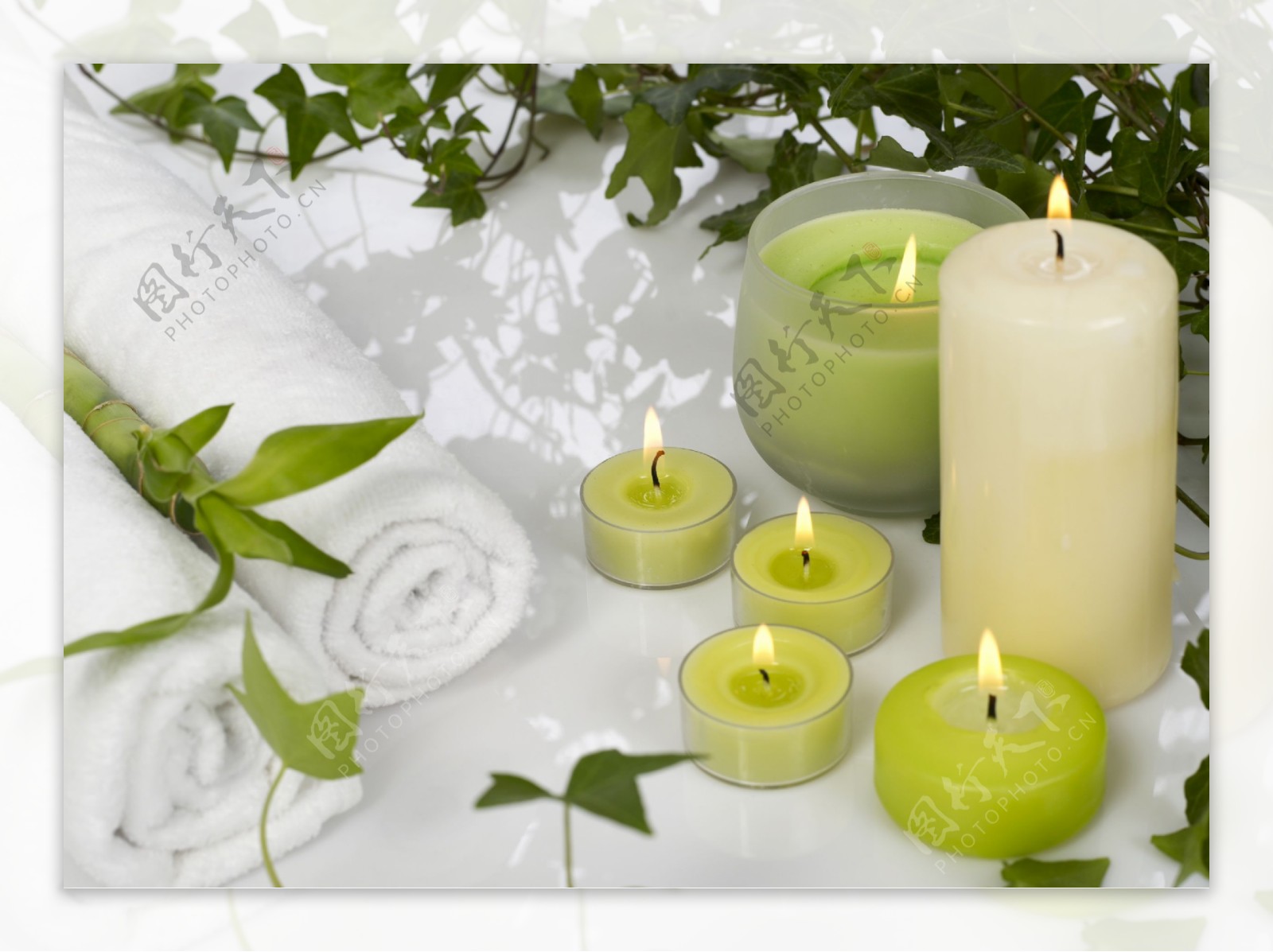 燃烧的蜡烛和绿叶毛巾图片