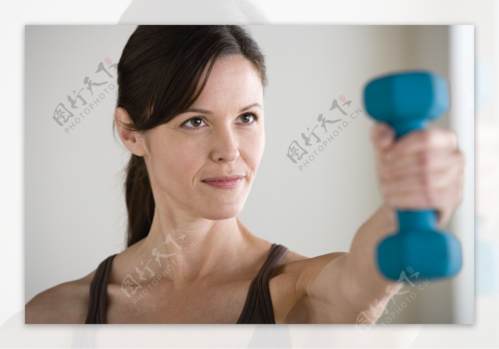 认真锻炼手臂的健身女性图片