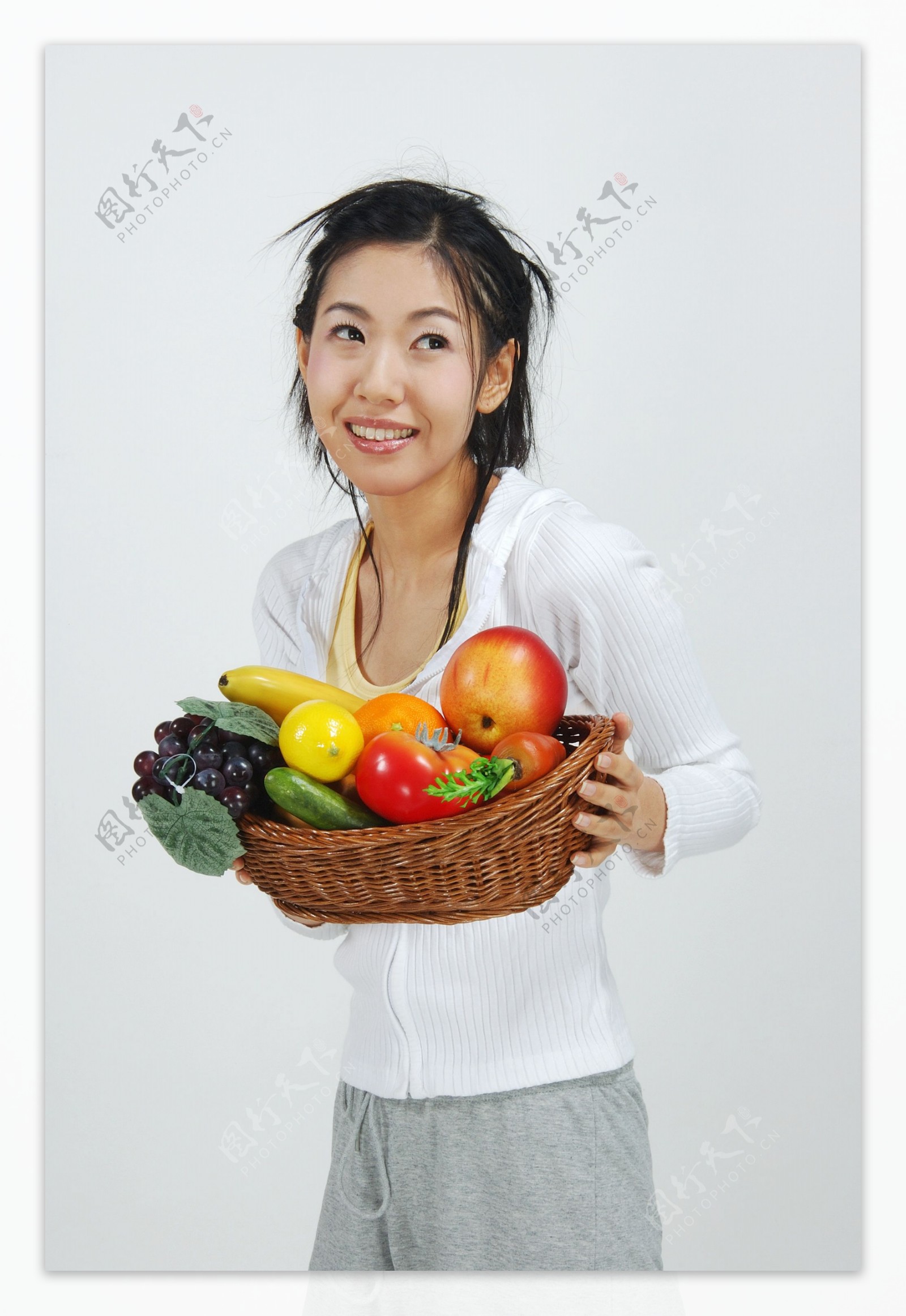 抱着一篮水果的女孩图片