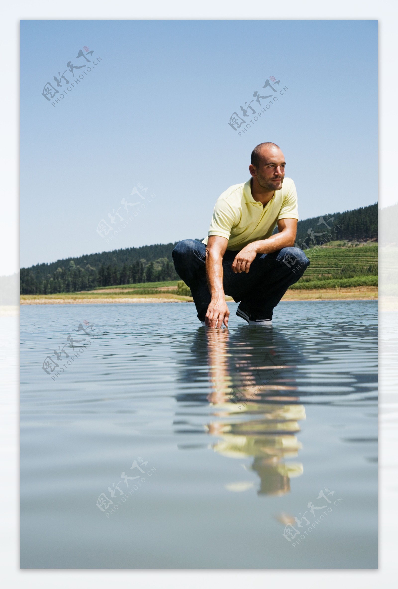 蹲在水面上的外国男人图片